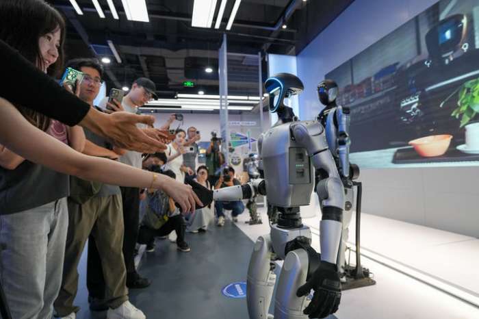 베이징 경제개발구에 위치한 로봇 세계 최초의 맞춤형 스마트 로봇 4S 매장(ROBOT MALL)에서 관람객이 한 휴머노이드 로봇과 악수하고 있다(2025년 8월 6일).png.jpg