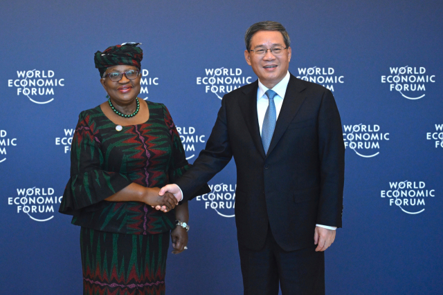 이중국 국무원 총리 리창이 WTO 사무총장 이웨이라와 악수하고 있다.png